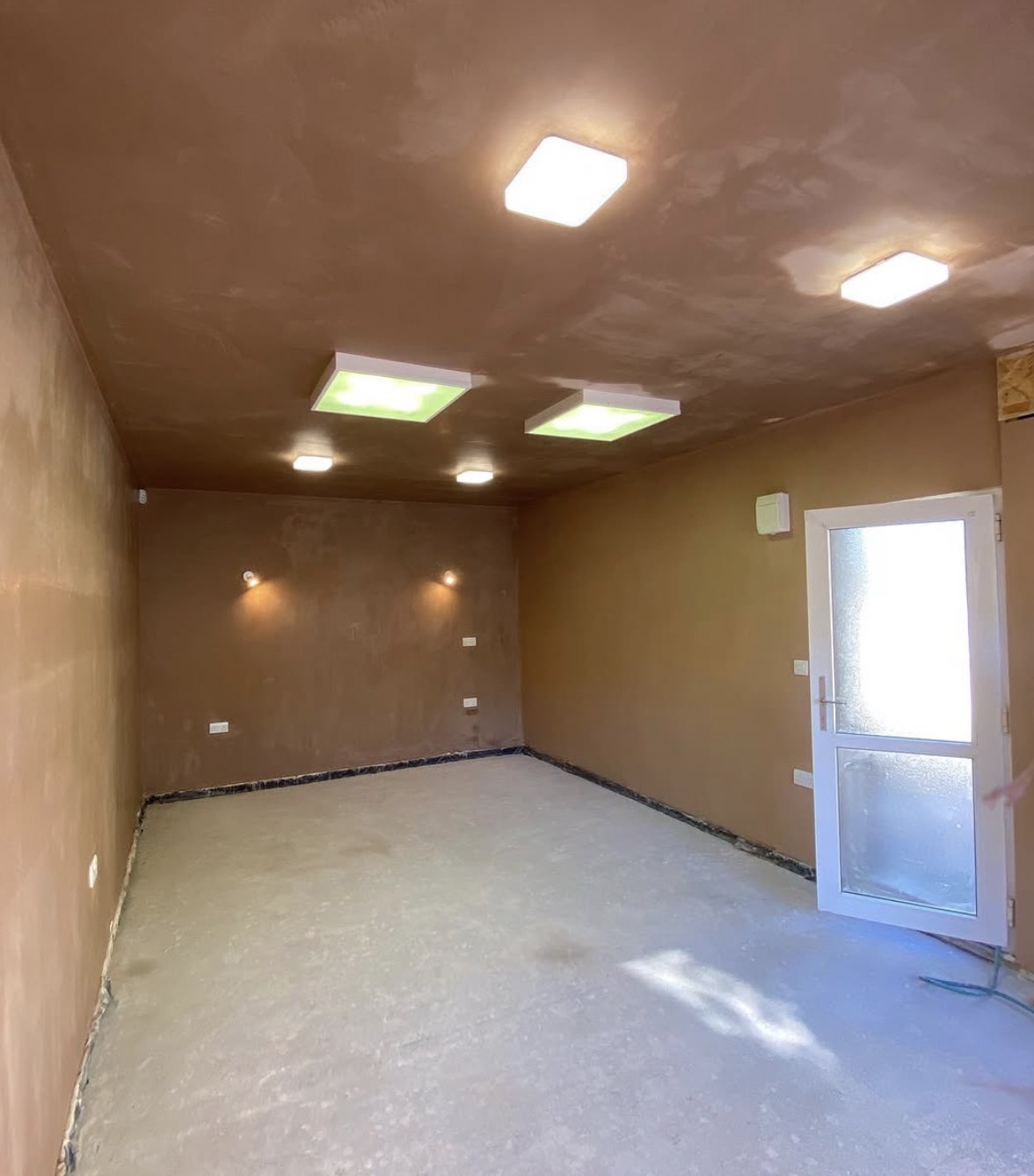 Freshly plastered room and ceiling with recessed lights and roof lights