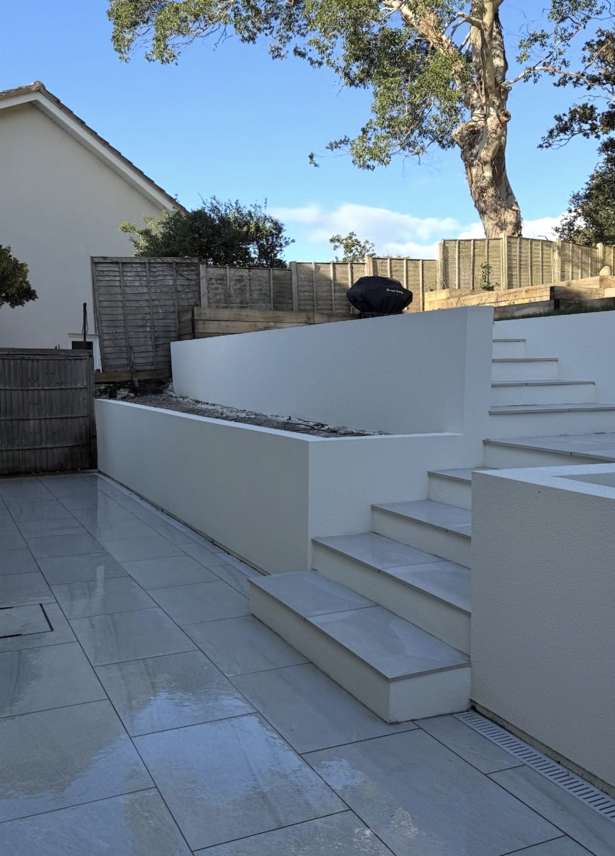 Pearl white K Rend TC15 spray render finish on curved garden retaining walls and steps